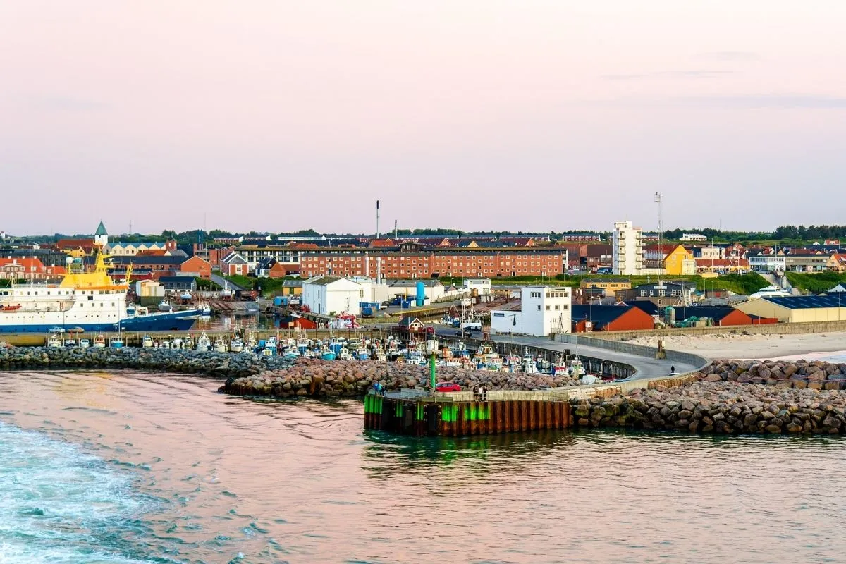Hirtshals havn og byen bagved set fra vandet, med molen og fiskerflåden i forgrunden