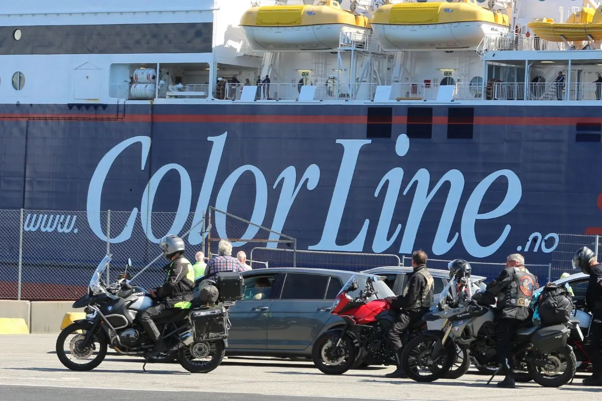 Motorcyklister og biler venter i opmarchbåsene ved siden af et Color Line-skib, motorerne slukket